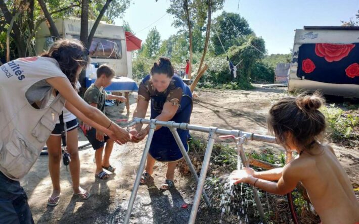 Animation collective lors des travaux de l'installation d'une rampe d'eau sur un bidonville. La réduction des charges d'eau est une célébration pour les femmes et les enfants qui sont les principaux groupes en charges de ces corvées - Crédits photo : Solidarités International